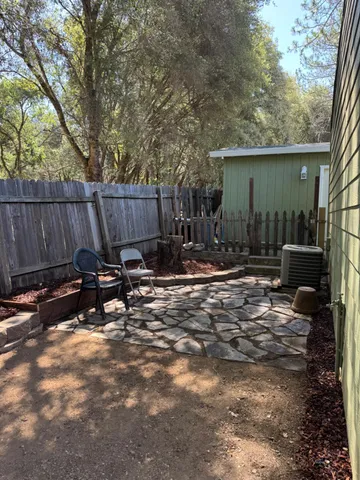a view of a backyard with a table and chairs with wooden fence