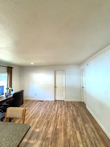 a view of an empty room and wooden floor