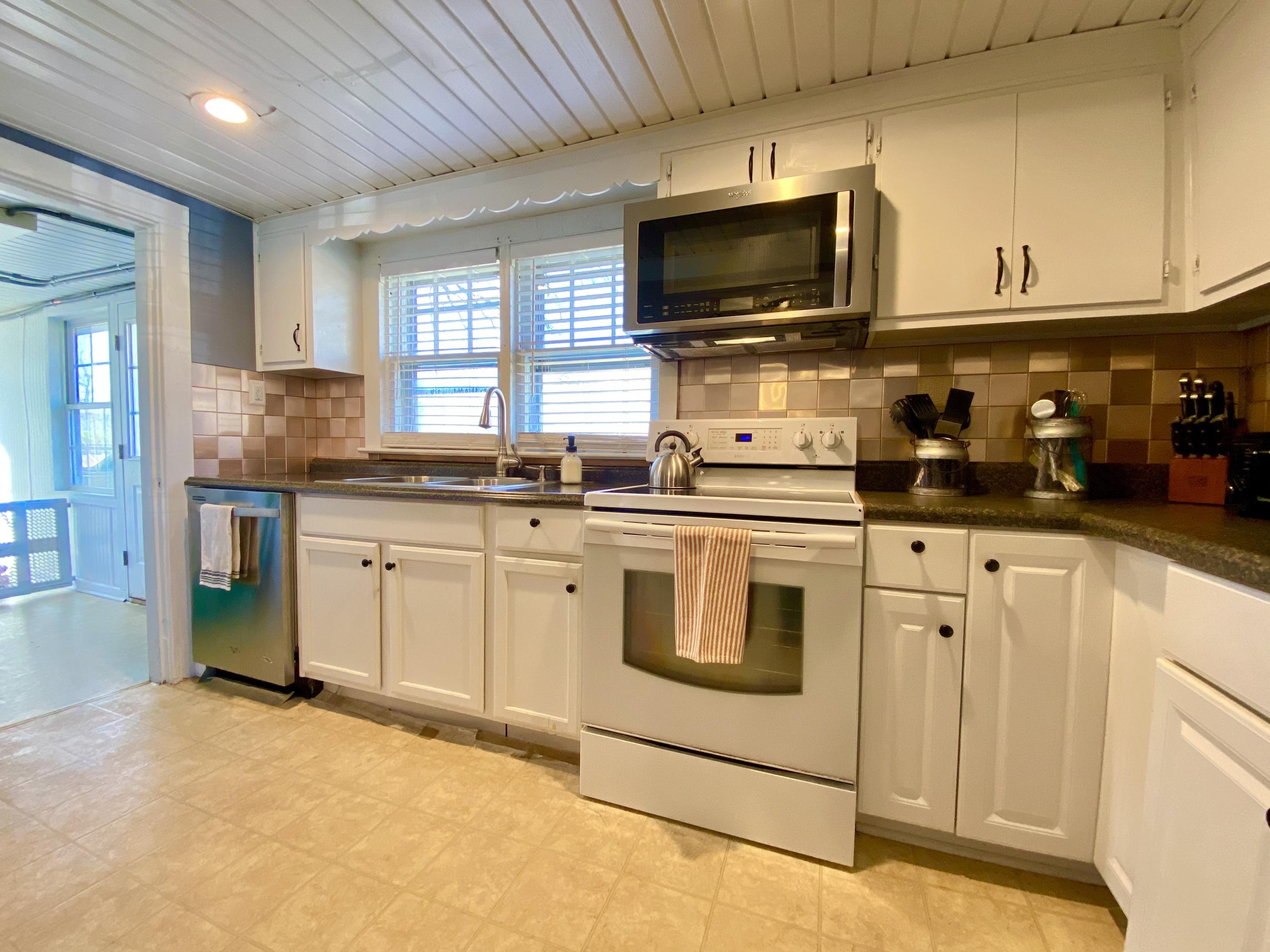 1121 Stone Mill Road Hurt, VA 24563 - Photo 12 of 28 a kitchen with stainless steel appliances granite countertop a stove top oven a sink dishwasher and white cabinets with wooden floor