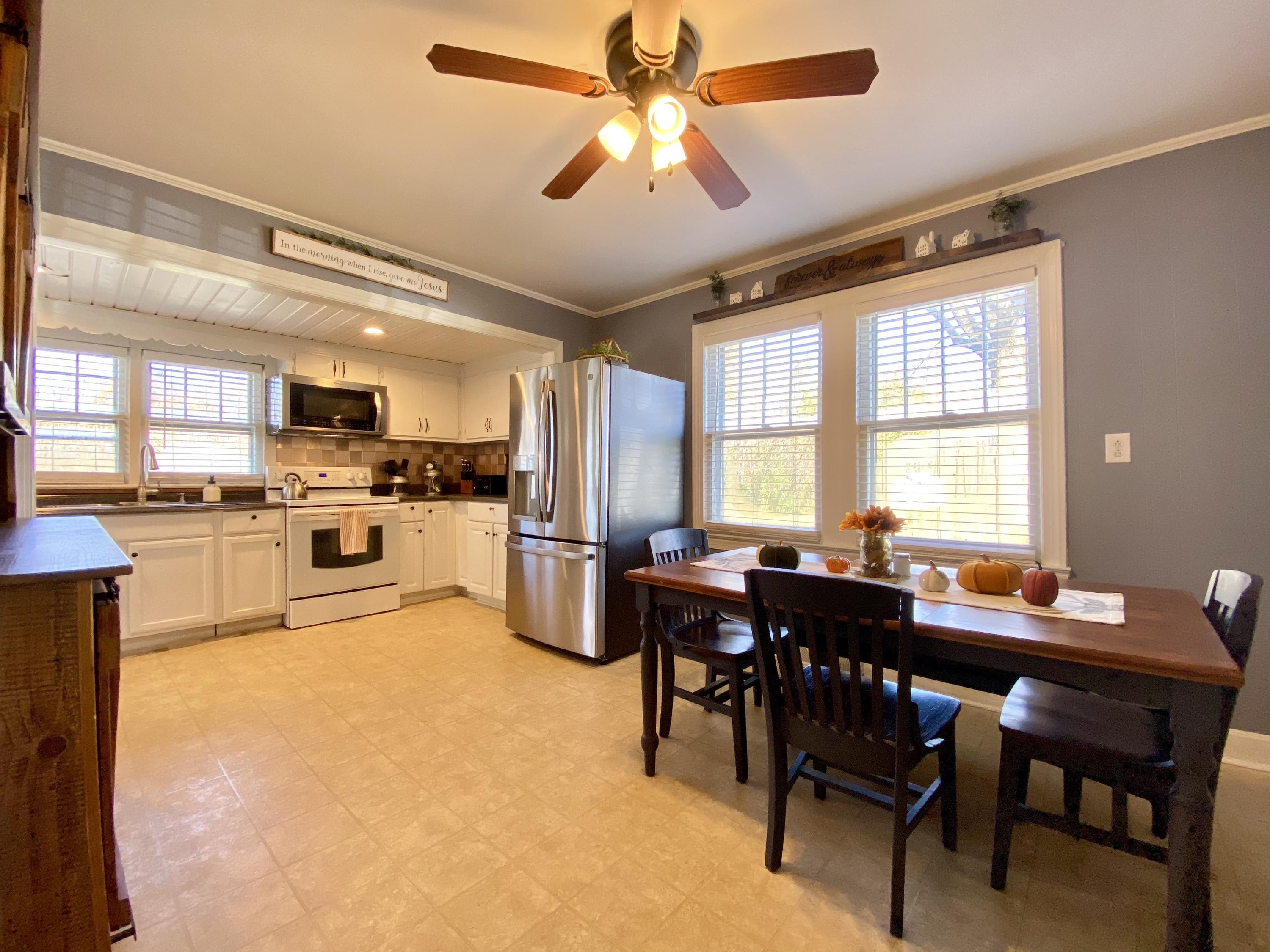 1121 Stone Mill Road Hurt, VA 24563 - Photo 9 of 28 a kitchen with a table chairs refrigerator and cabinets