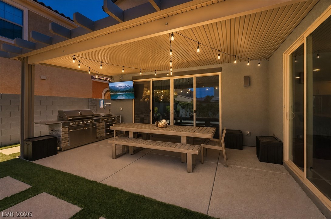 2166 Trivero Street Henderson, NV 89044 - Photo 49 of 61 Entertain guests al fresco with this covered patio featuring an outdoor kitchen and string lights.