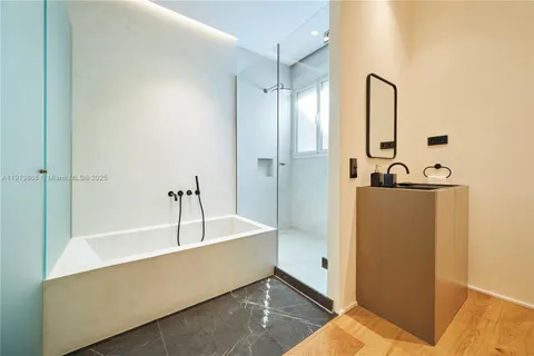 a bathroom with a tub sink and mirror