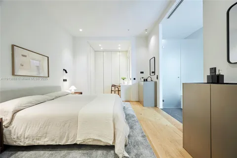 a spacious bedroom with a bed and a refrigerator
