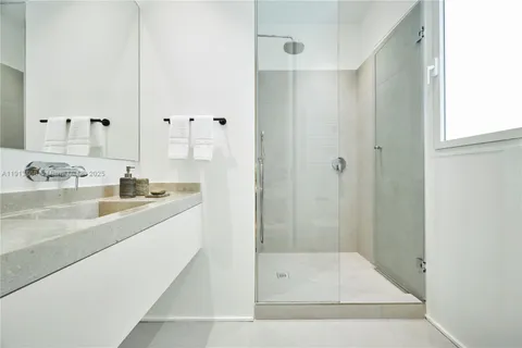 a bathroom with a shower sink and mirror