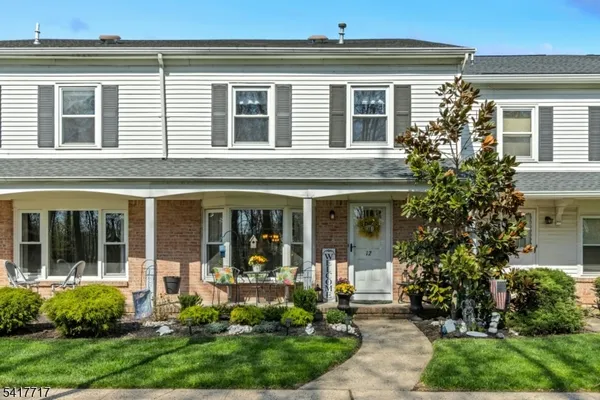 a kitchen with stainless steel appliances granite countertop a stove top oven a sink dishwasher and white cabinets with wooden floor