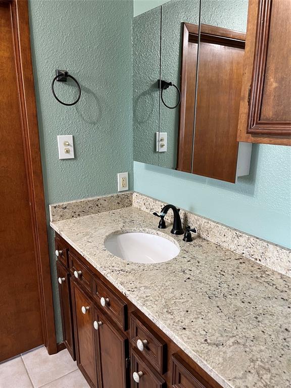 2190 West Fm 574 Road West Mullin, TX 76864 - Photo 30 of 40 a bathroom with a granite countertop sink and a mirror