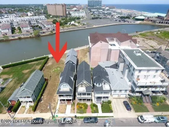 an aerial view of residential houses with outdoor space and lake view