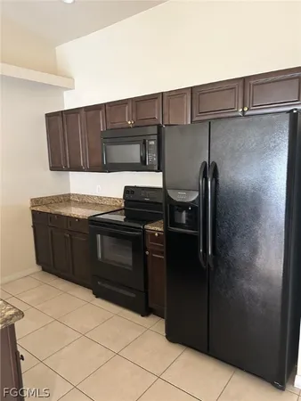a kitchen with granite countertop a refrigerator and a stove