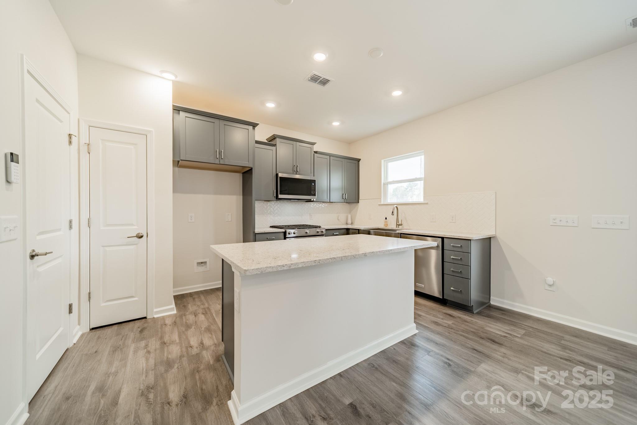 6012 Chumbley Pt Road Charlotte, NC 28215 - Photo 14 of 46 a kitchen with stainless steel appliances a sink stove and refrigerator