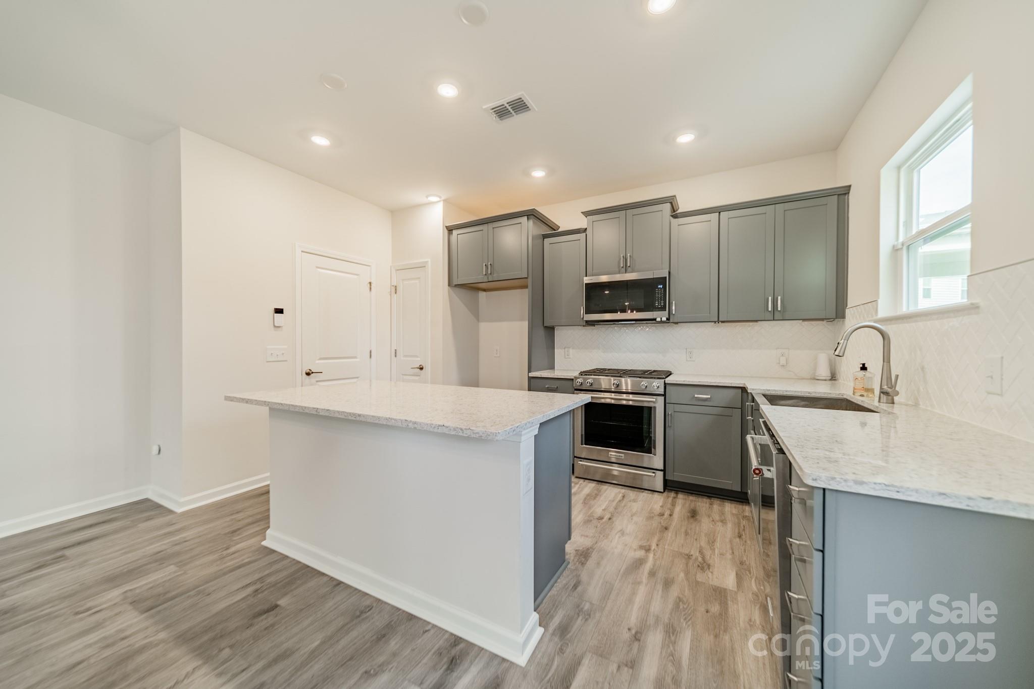 6012 Chumbley Pt Road Charlotte, NC 28215 - Photo 15 of 46 a kitchen with stainless steel appliances granite countertop a sink stove and refrigerator