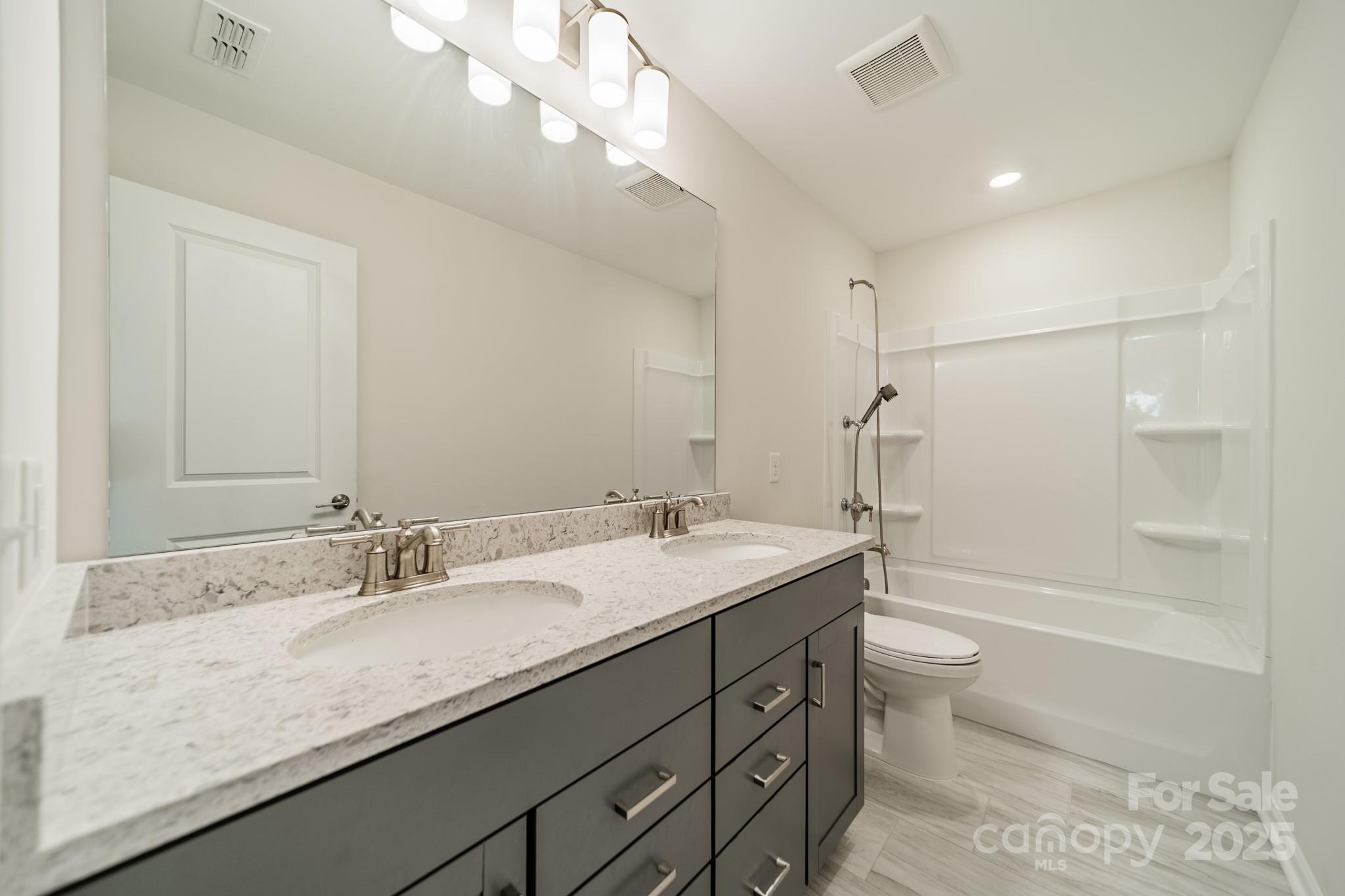 6012 Chumbley Pt Road Charlotte, NC 28215 - Photo 24 of 46 a bathroom with a granite countertop sink a toilet and bathtub