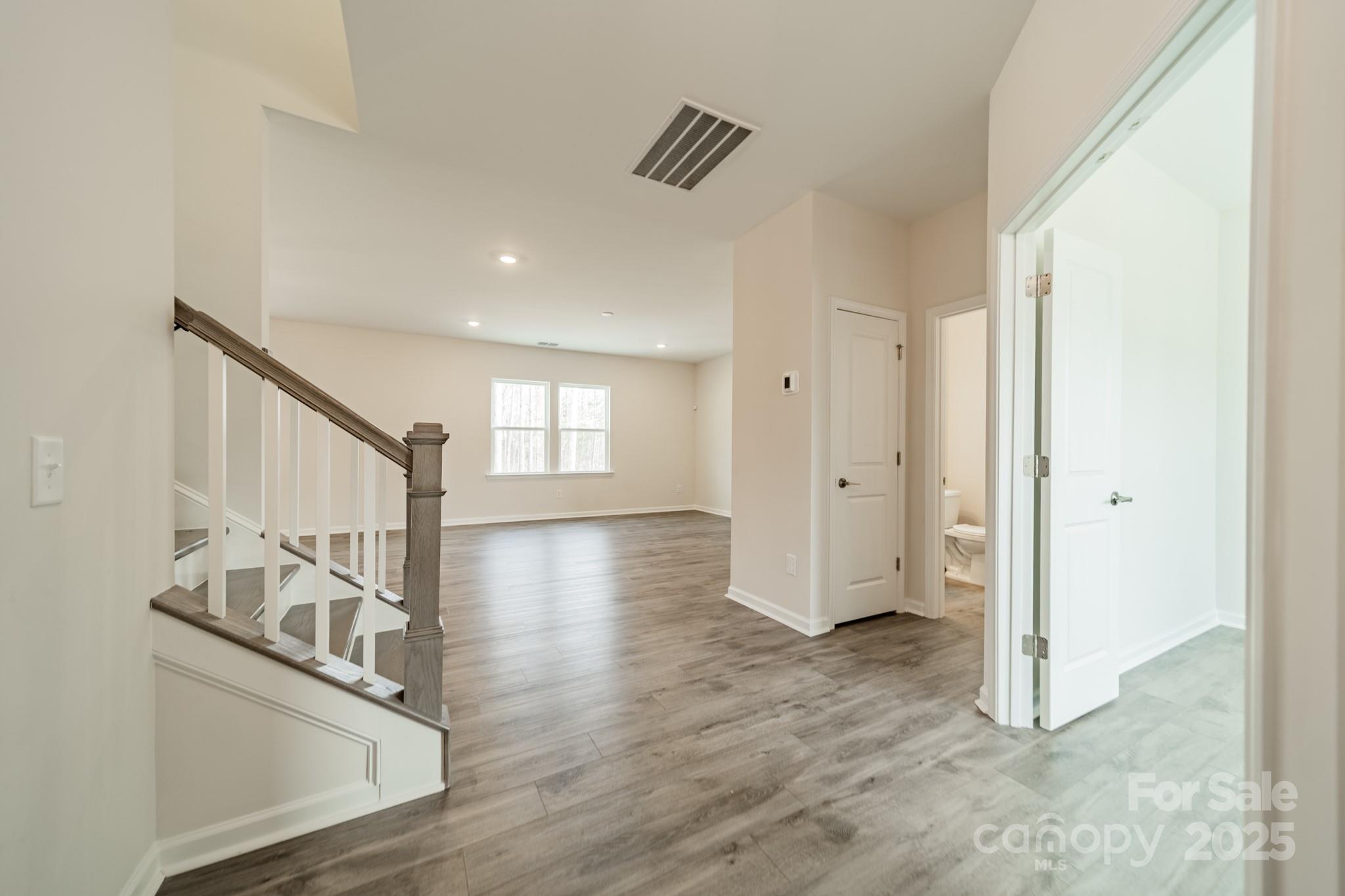 6012 Chumbley Pt Road Charlotte, NC 28215 - Photo 3 of 46 a view of a hallway with wooden floor and staircase