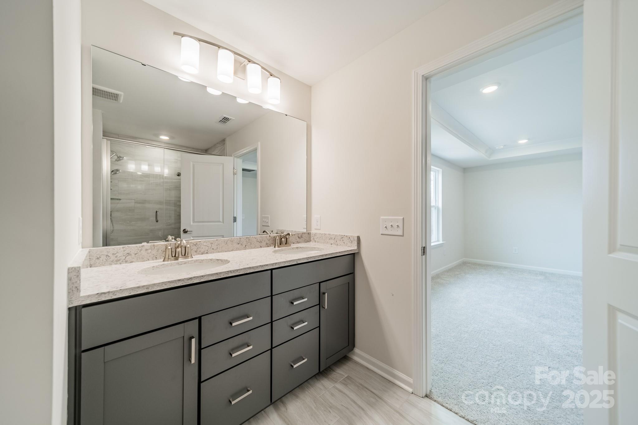 6012 Chumbley Pt Road Charlotte, NC 28215 - Photo 32 of 46 a bathroom with a double vanity sink and mirror
