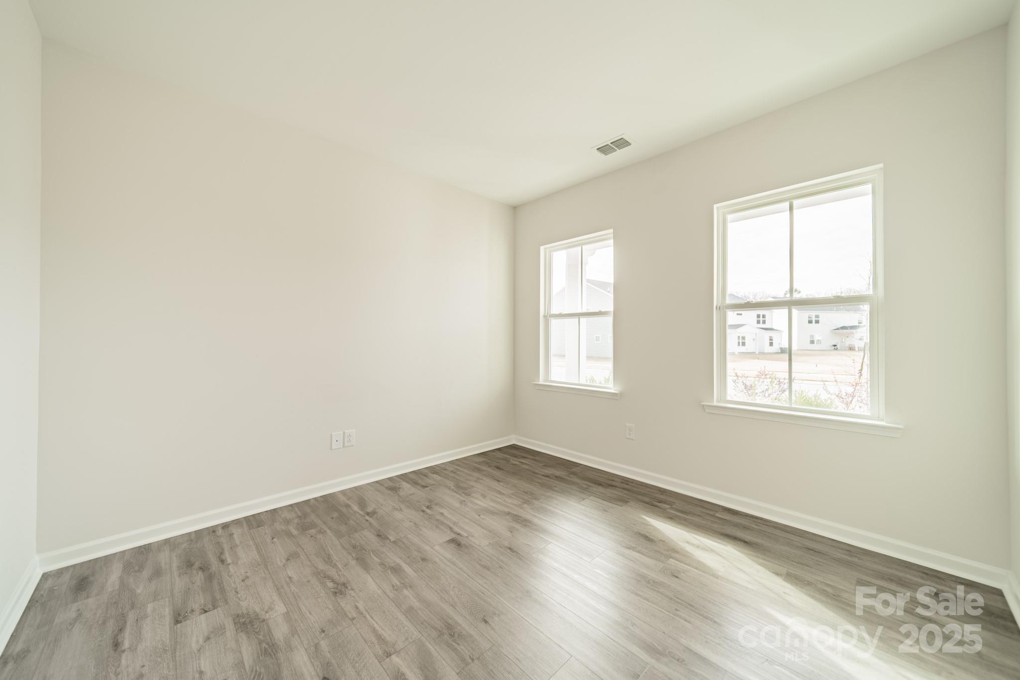 6012 Chumbley Pt Road Charlotte, NC 28215 - Photo 5 of 46 an empty room with wooden floor and windows