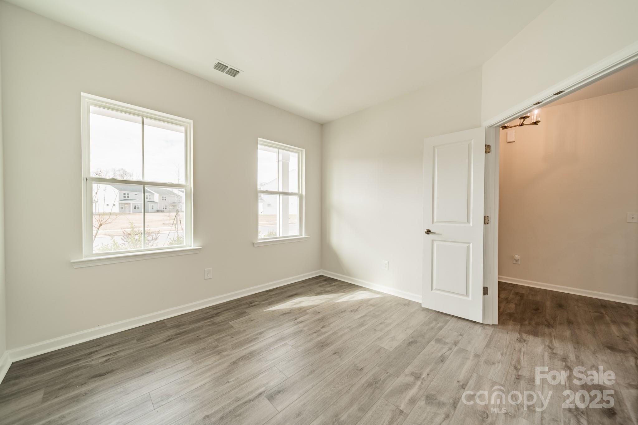 6012 Chumbley Pt Road Charlotte, NC 28215 - Photo 6 of 46 an empty room with wooden floor and windows