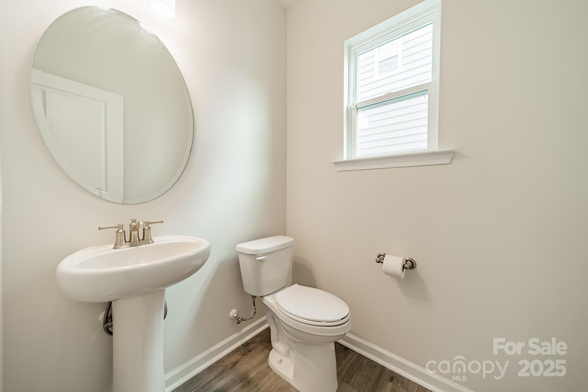 6012 Chumbley Pt Road Charlotte, NC 28215 - Photo 8 of 46 a bathroom with a sink a mirror and a toilet