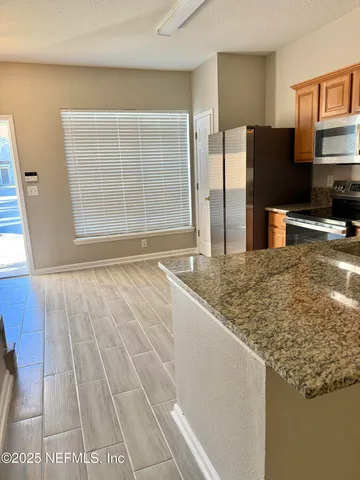 a kitchen with granite countertop a refrigerator and a sink