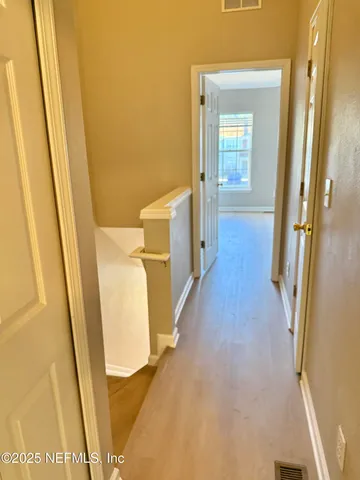 a view of a hallway with wooden floor