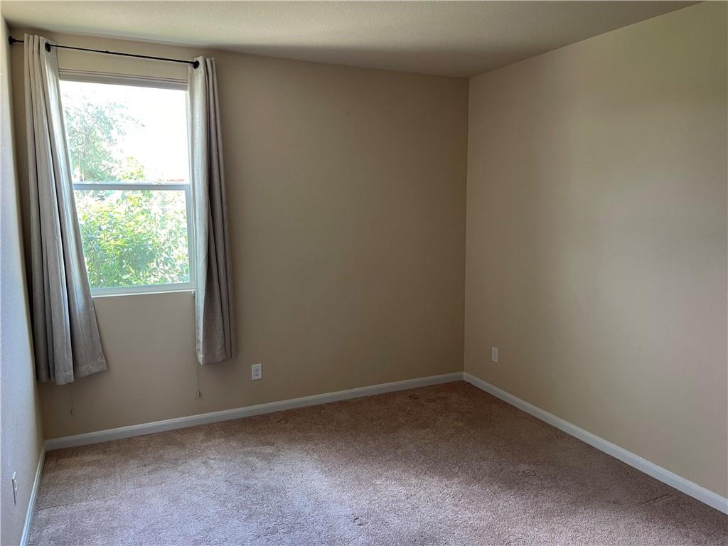 1420 Nevarez Kyle, TX 78640 - Photo 6 of 9 A well-lit bedroom features plush carpeting and a large window providing verdant outdoor views.