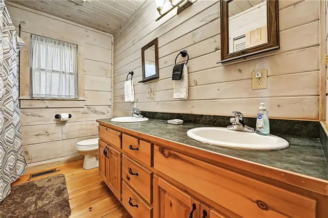 a bathroom with a double vanity sink a mirror and a bathtub