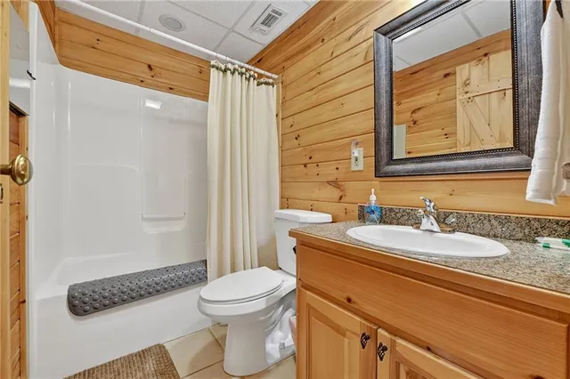 a bathroom with a granite countertop sink mirror vanity and toilet