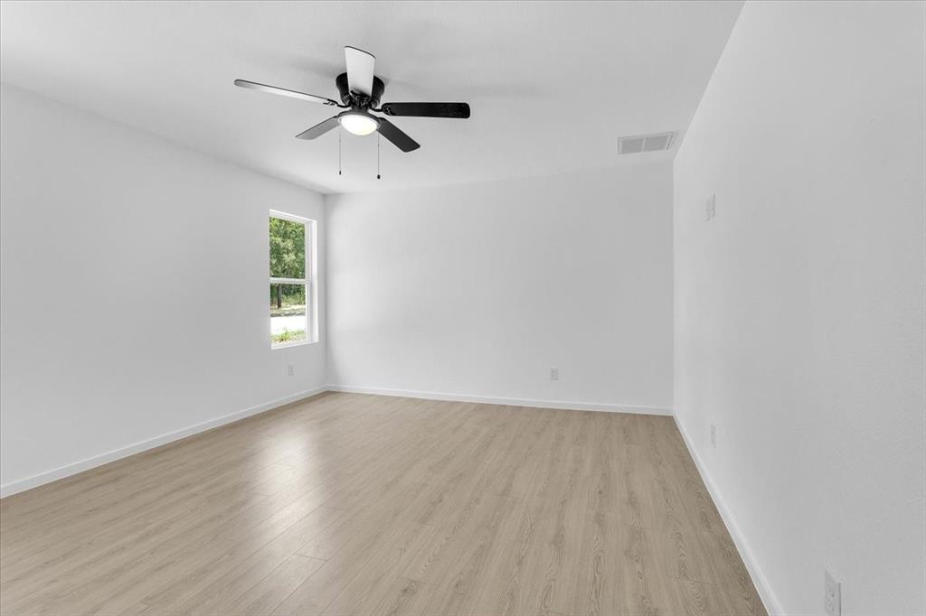415 East Monterey Street Denison, TX 75021 - Photo 19 of 23 a view of empty room with wooden floor and fan