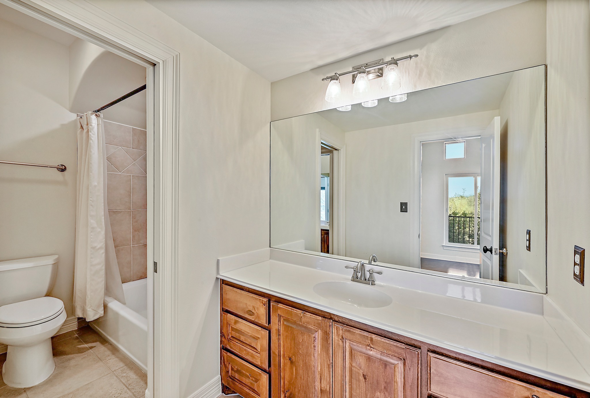 13201 Winding Creek Road Austin, TX 78736 - Photo 24 of 39 a bathroom with a sink a toilet and a large mirror