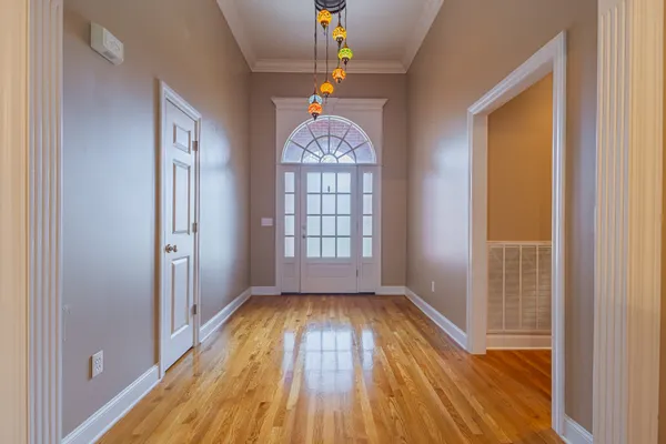 a view of empty room with window and wooden floor