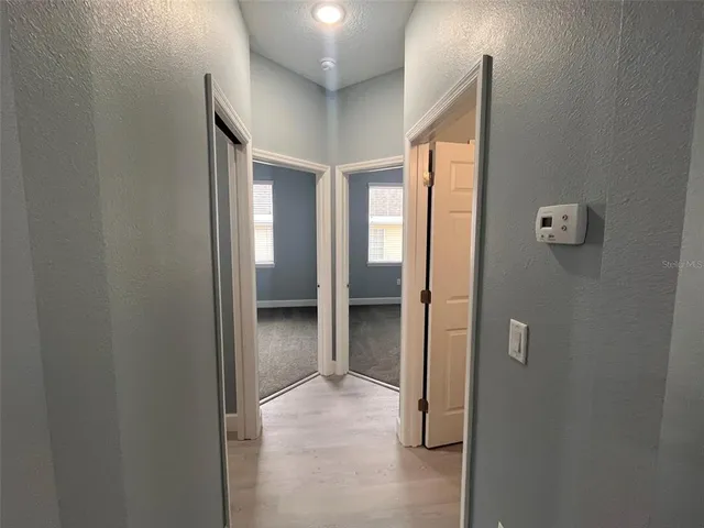 a view of a hallway with closet and wooden floor