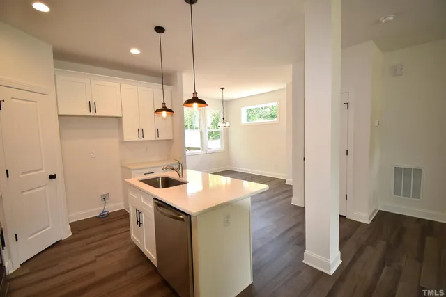 a kitchen with a sink stove and wooden floor