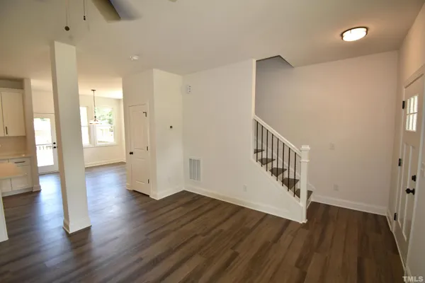 a view of a hallway with wooden floor and staircase