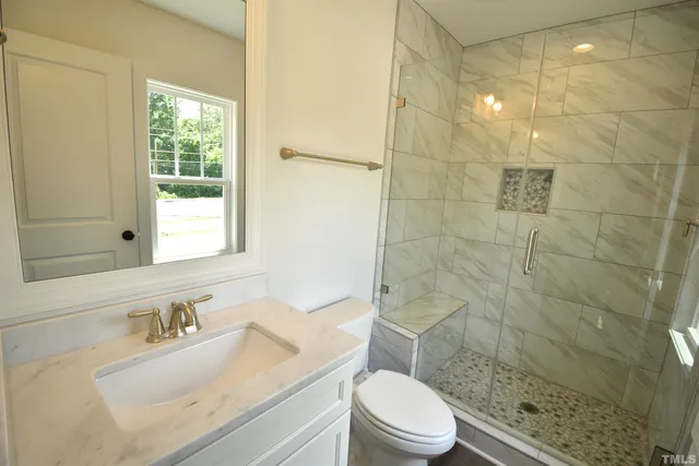 a bathroom with a sink a toilet and shower