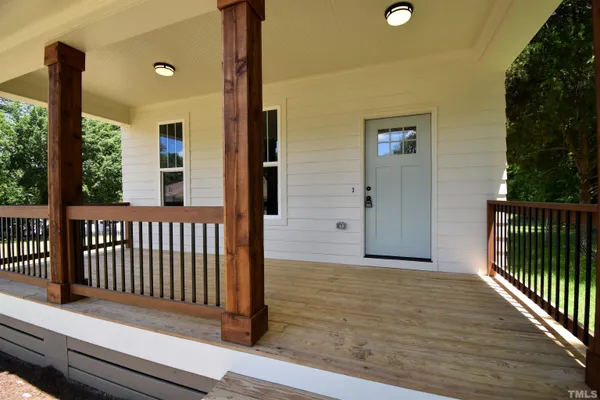 a view of a porch with wooden floor and fence