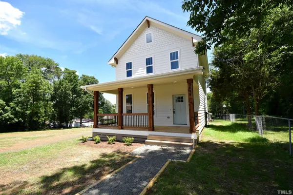 a view of a house with backyard and trees