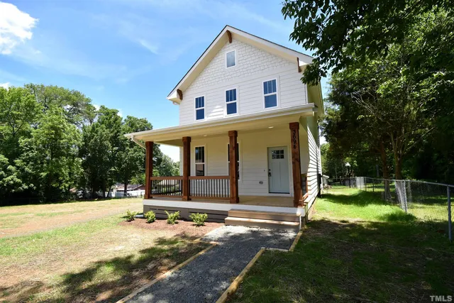 a view of a house with backyard and trees