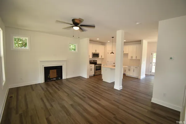 a view of empty room with wooden floor and fireplace