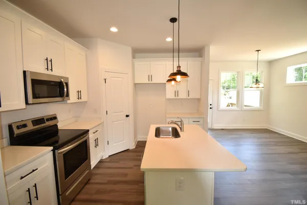 a kitchen with a sink a microwave and cabinets