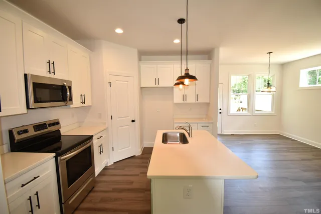 a kitchen with a sink a microwave and cabinets