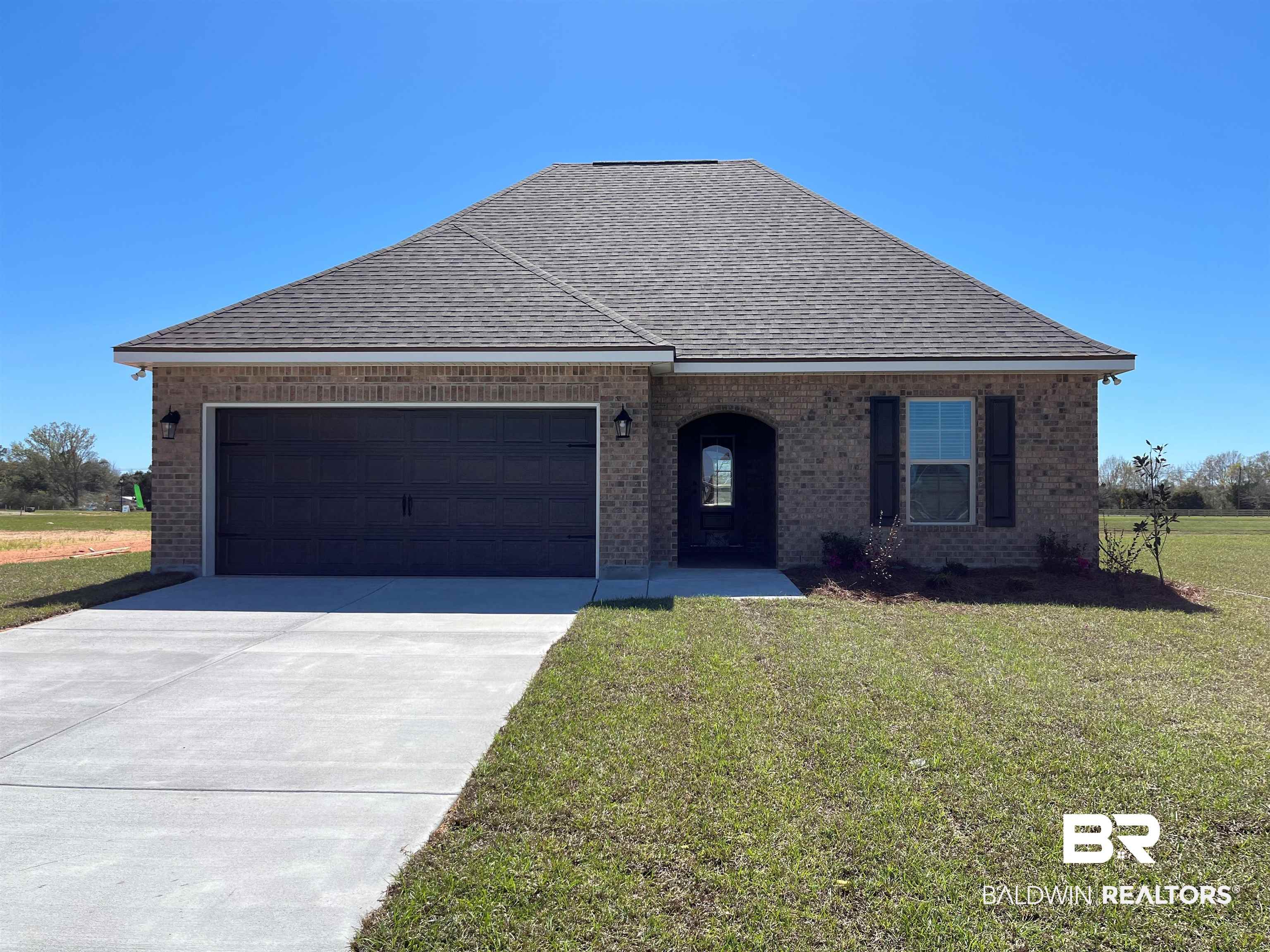 17964 Piney Circle Foley, AL 36535 - Photo 1 of 3 View of front of property featuring brick siding, a garage, driveway, a front yard, and roof with shingles