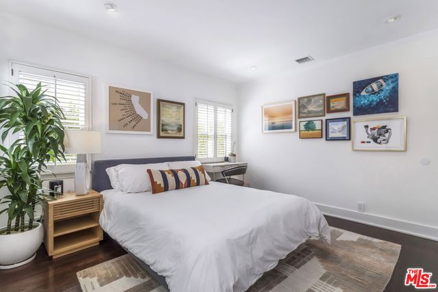 a spacious bedroom with a bed and wooden floor