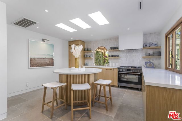 a kitchen with a sink and a large mirror