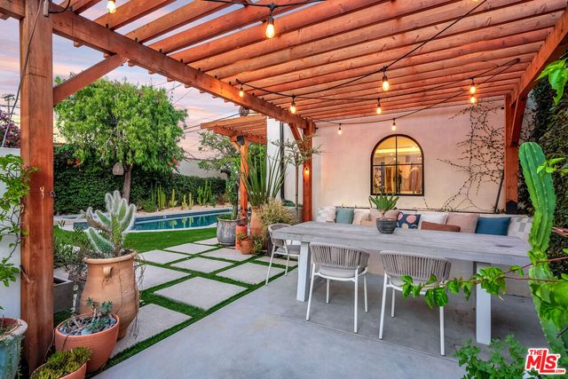 a view of a patio with table and chairs potted plants