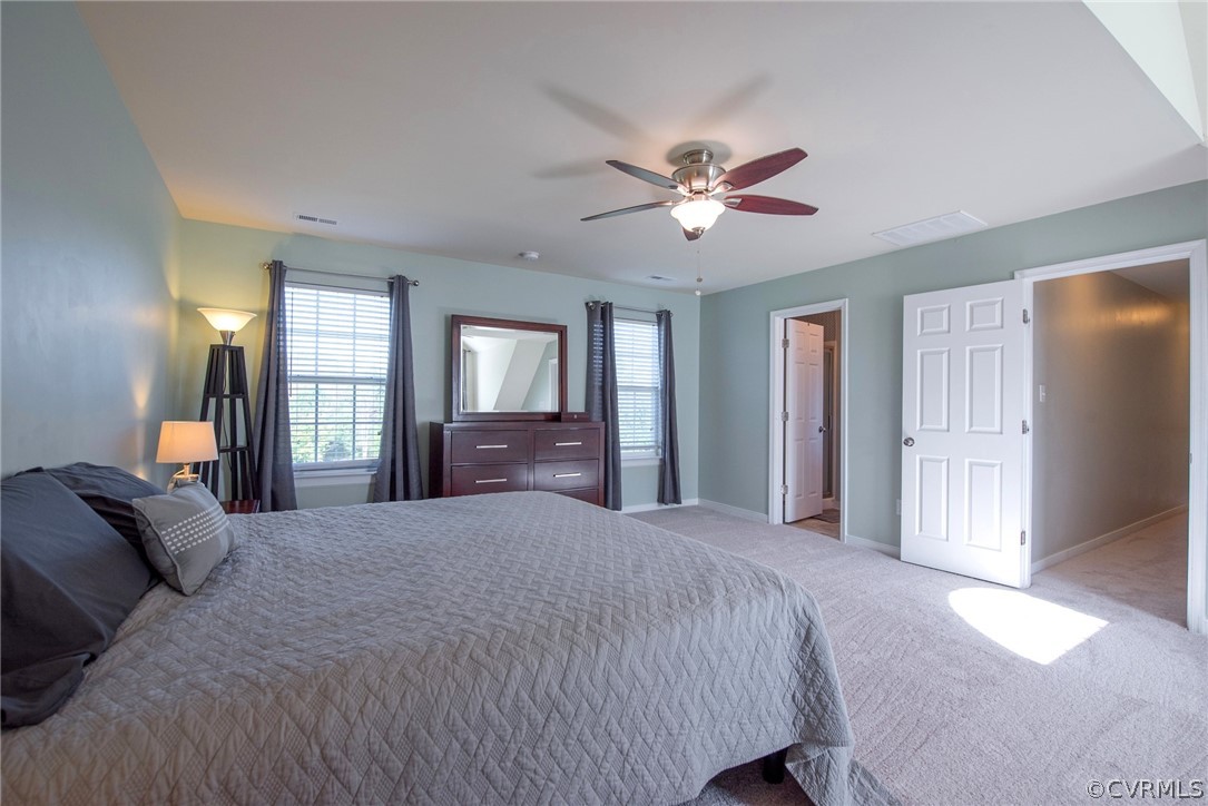 552 Waltons Store Road Louisa, VA 23093 - Photo 35 of 50 a spacious bedroom with a large bed and a chandelier