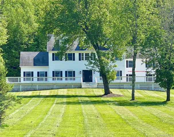 a front view of a house with swimming pool and porch