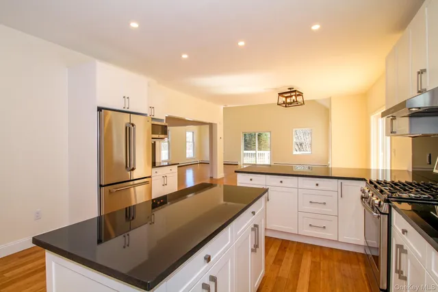 a kitchen with stainless steel appliances granite countertop a sink a stove and refrigerator