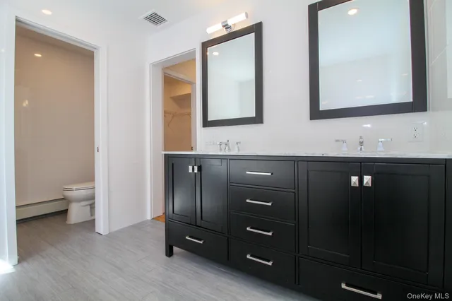 a bathroom with a double vanity sink and a mirror
