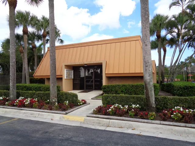 a front view of a house with a yard and potted plants