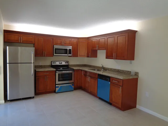 a kitchen with stainless steel appliances granite countertop a refrigerator and a stove