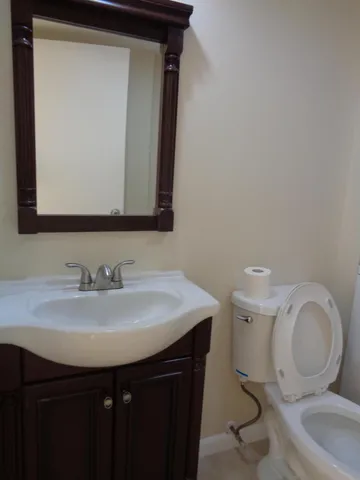 a bathroom with a toilet sink and mirror