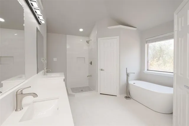 a bathroom with a tub sink and mirror